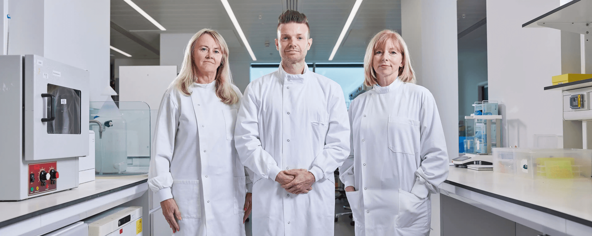 Photo of three researchers Caroline, Richard and Sarah standing defiant and proud in a lab.