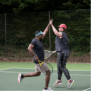A photo of two people playing tennis.