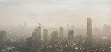 A panoramic landscape view of a city skyscape showing smog and polluted air