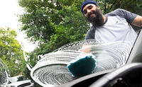 Bearded man washing a car