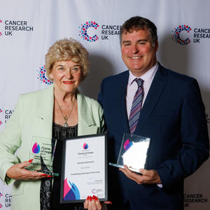 Brenda and another winner holding their Flame of Hope certificates and trophies