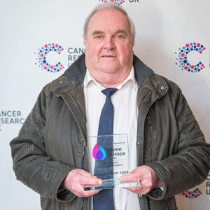 Graham holding his Flame of Hope trophy