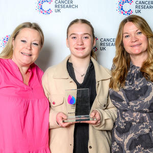 Heidi holding her Flame of Hope award with two guests