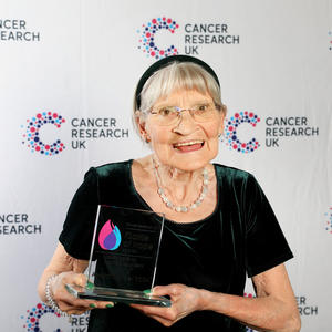 Jean holding her Flame of Hope trophy