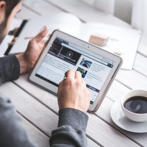 man on tablet with coffee