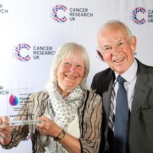 Margaret holding her Flame of Hope trophy with guest