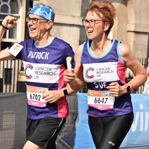 Patrick and Sue smiling running wearing their CRUK running t-shirts