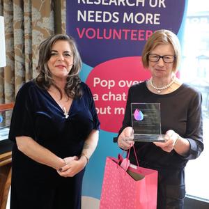 Amy holding her Flame of Hope trophy with guest