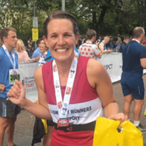 Rachel Avon smiling after a running event wearing her medal