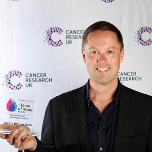 Richard holding his Flame of Hope award