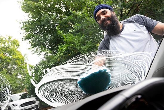 Bearded man washing a car