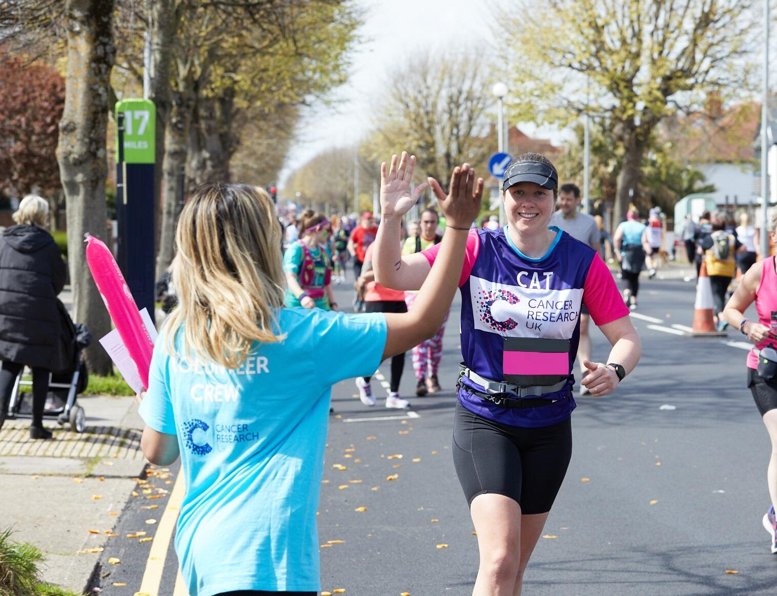 Smiling woman running for Cancer Research UK