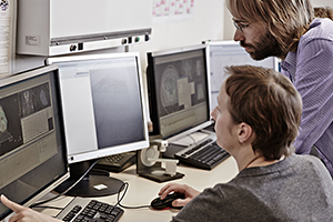 Photo of 2 people looking at a computer