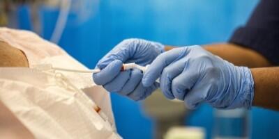 Image of a healthcare professional's gloved hands giving treatment to a patient