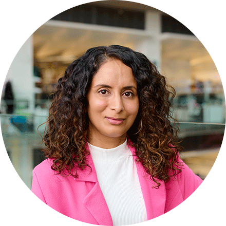 Portrait of Raj in a white top and a bright pink blazer