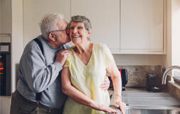 A photo of a couple standing in a kitchen 