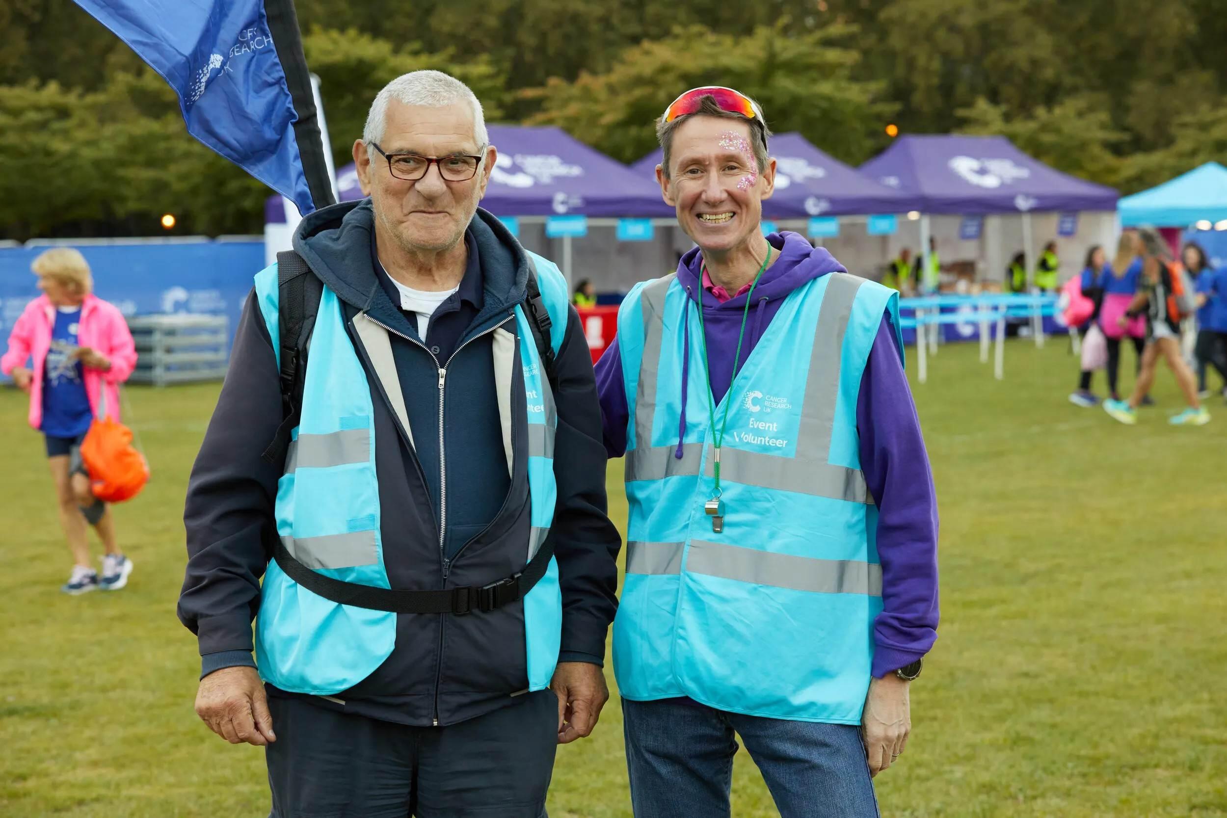 Two event volunteers together smiling 