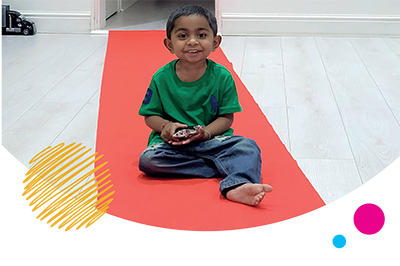 Diyan sitting on a red carpet