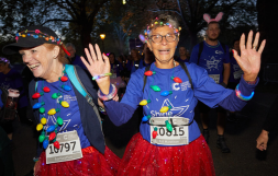 Image of two Shine Night Walk participants wearing red tutus and multi-coloured lights