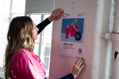 Woman putting up a fundraising poster