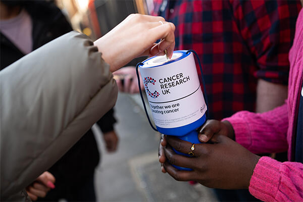 People putting money in a collection goblet