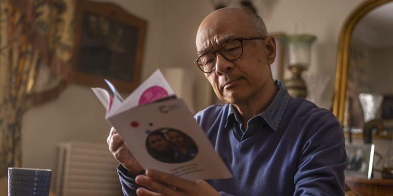 Photo of a man reading a Cancer Research UK pamphlet