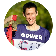 Photo of an event participant wearing a CRUK shirt and holding multiple medals