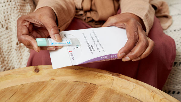 Person puts their FIT kit in an envelope