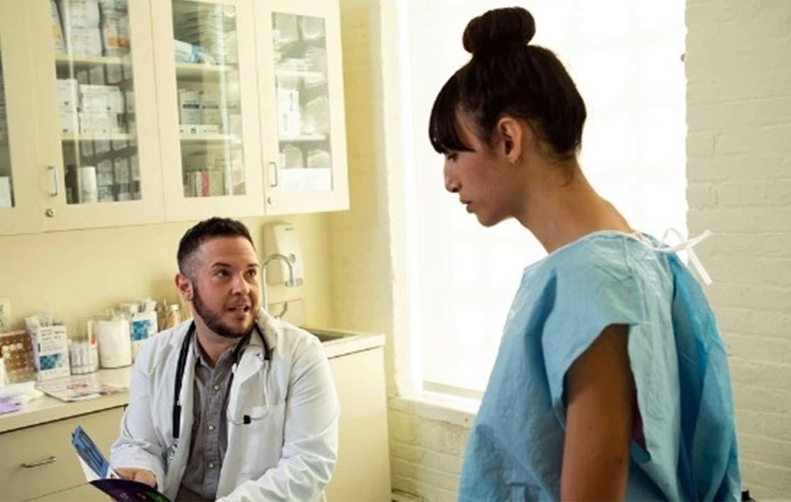 A photo of a patient talking to a doctor at a clinic