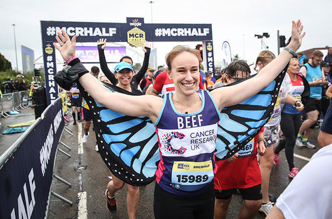 A female runner wearing butterfly wings starting her race at the Manchester Half Marathon