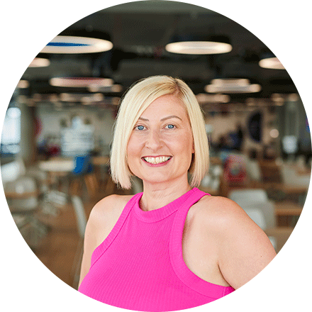 Portrait of Sherrill in the office wearing a pink tank smiling on the camera