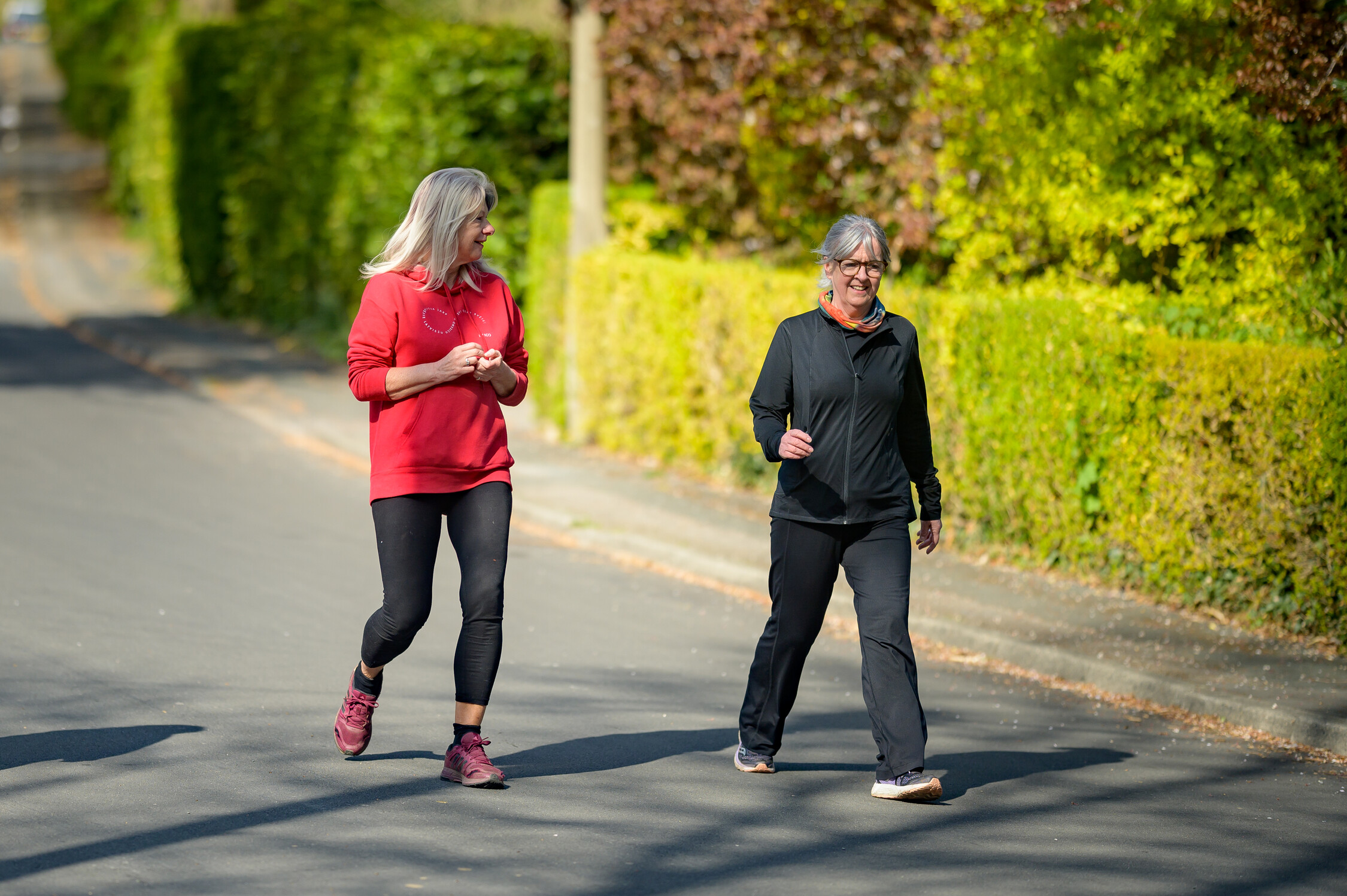 Two women walking along a road