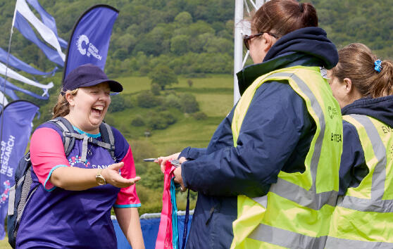 A Big Hike volunteer giving a medal to a participant at the end of their hike 