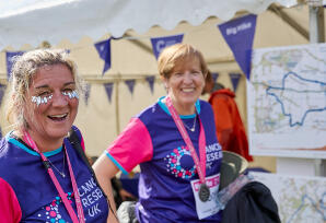 Two Big Hike participants with glitters on their faces smiling at the camera