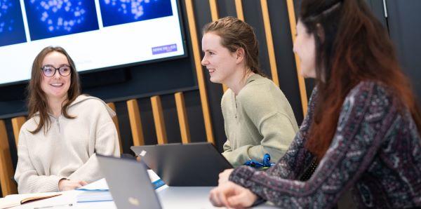 Researchers in a conference room discussing work together