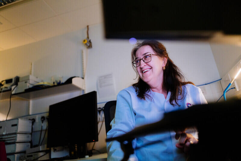 Researcher smiling in CRUK branded shirt