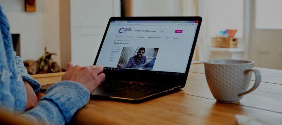 Woman using a laptop to look at a CRUK web page about talking to your doctor