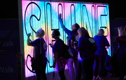 supporters writing on an illuminated Shine board