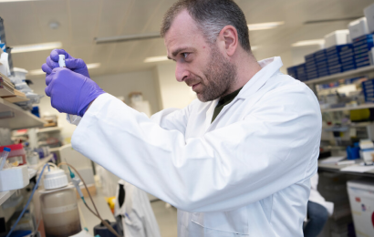 Image of a male researcher working in a white coat in a laboratory 