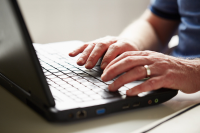 Hands typing on a laptop